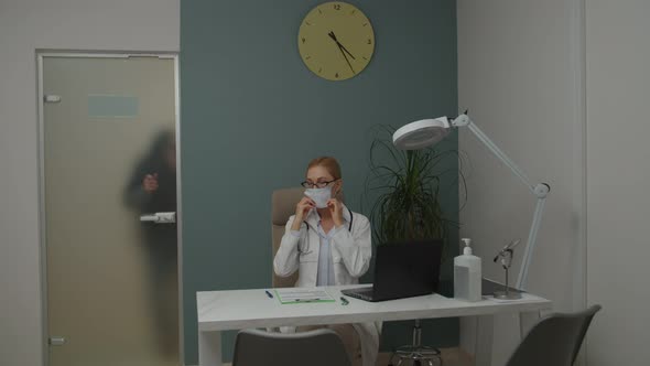 Female Doctor Putting on Mask Getting Ready to Patient Visit Indoors