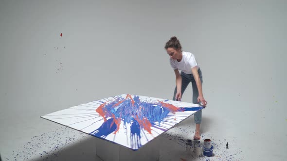 Experimental Painting Female Artist Draws By Pouring Paint and Rotating the Canvas a Young Talented