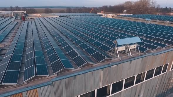 Many solar panels on a roof of a huge building.