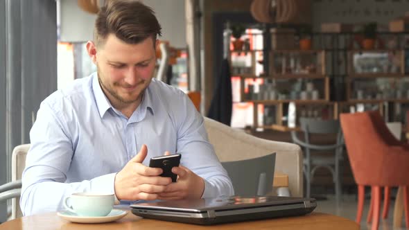 Businessman Talks on the Phone at the Cafe