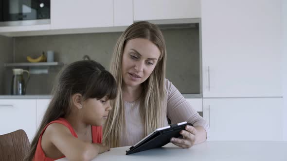 Mom Showing Content on Tablet To Little Daughter