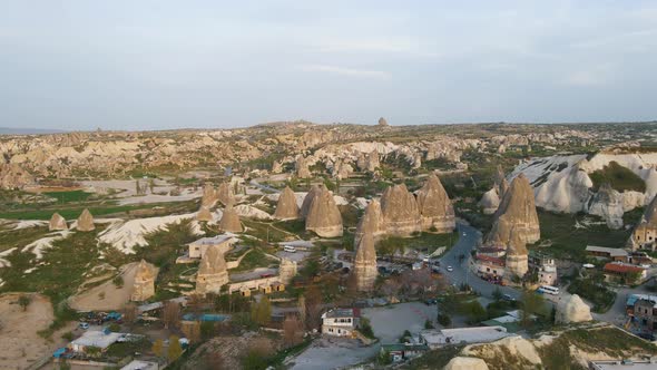 Aerial forwarding shot of beautiful fairy chimneys along with residential houses in Cappadocia, Turk