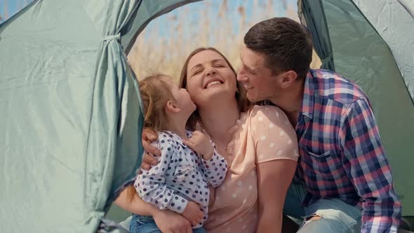 Family with a Little Girl in Nature Resting in a Tourist Tent