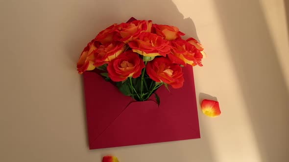 Bouquet of Red Roses Decorated in Paper Envelope on Beige Background