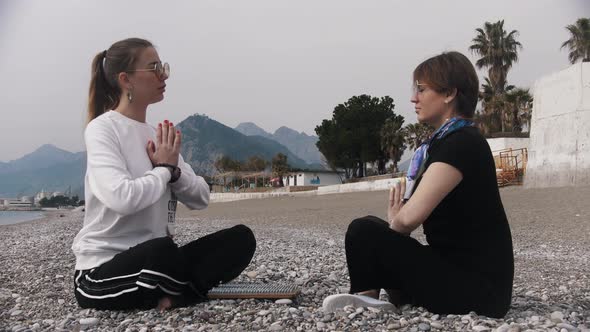 Two Women Sitting on the Seashore By the Sadhu Board and Meditating