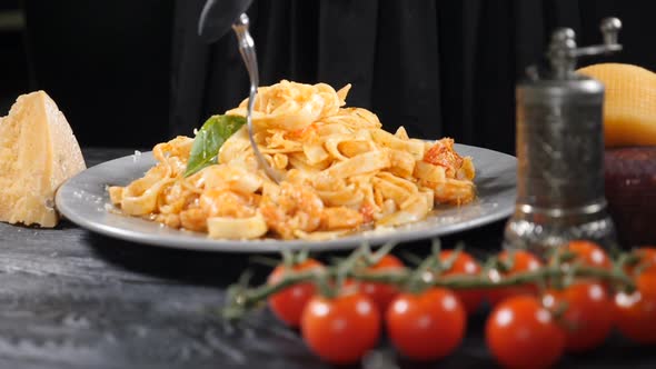 Hand in Black Glove Twisting and Taking Pasta with Fork