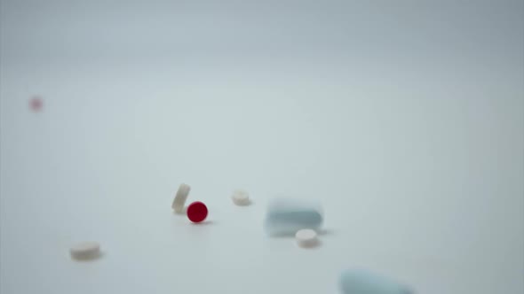 Medical pills falling on white background.