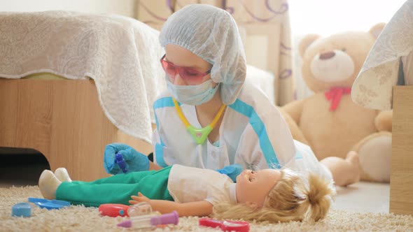 Beautiful Little Girl Playing Doctors with Doll at Home