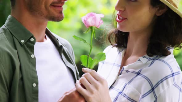 Romantic couple smelling rose in garden