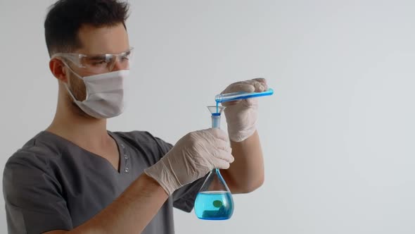 Laboratory Medic Pours Chemical Substance From Test Tube to the Flask