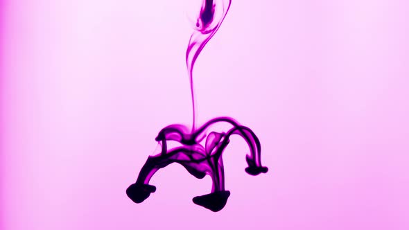 Creative Abstract Shot of Magenta Ink Dropped in Water on Pink Background