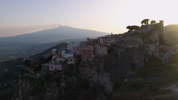 Rotating drone shot of Castelmola homes and buildings built on a natural terrace in Sicily Italy wit