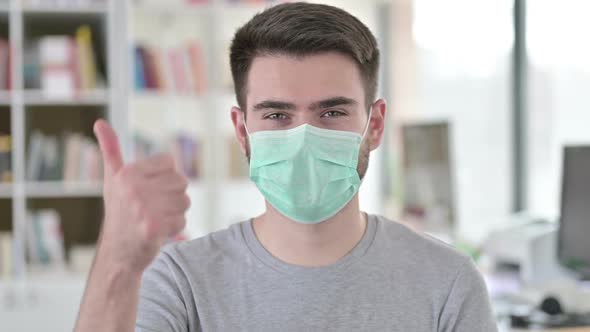 Portrait of Thumbs Up By Young Man with Face Mask