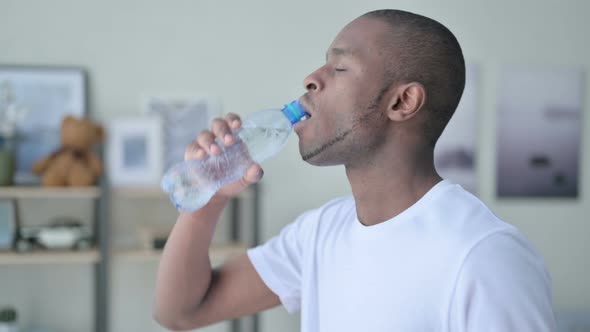 Close Up of Athletic African Man Drinking Water at Home