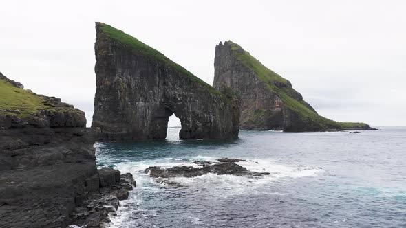 Aerial View of the Rocky Drangarnir Sea Stack in the Faroe Islands and the Skarosafossur Waterfall