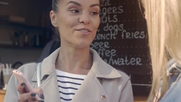 Young woman talking with her friend outdoor cafe