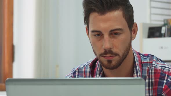 A Serious Guy Type Something on the Keyboard on the Computer