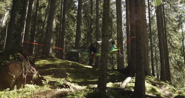 People Hanging Tent Camping in Forest Near Lake with Sun Flares Sunlight