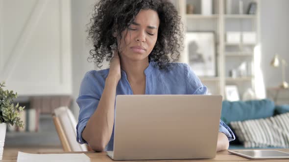 African Woman with Neck Pain Working on Laptop