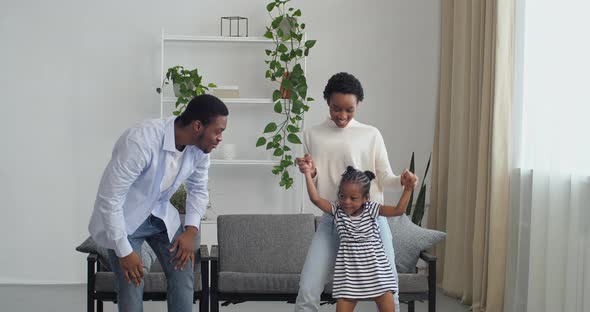 Happy Carefree Active African American Ethnic Couple Dancing with Cute Preschool Small Children