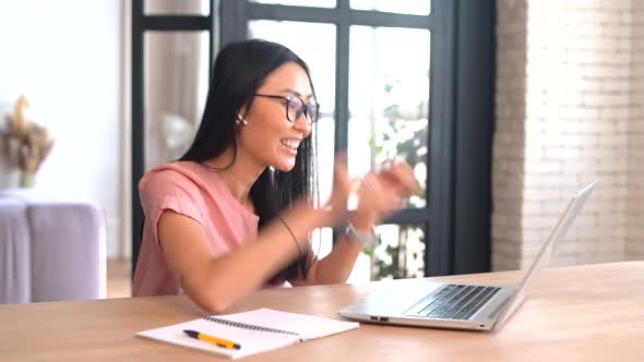 An Attractive Young Asian Woman is Using a Laptop for Remote Work