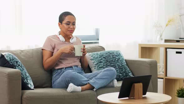 Woman with Tablet Pc Drinking Coffee at Home