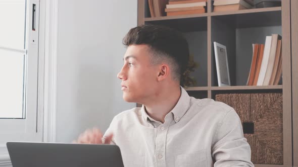 Caucasian reflexive teenager looking at laptop screen, reflexing on work, businessman