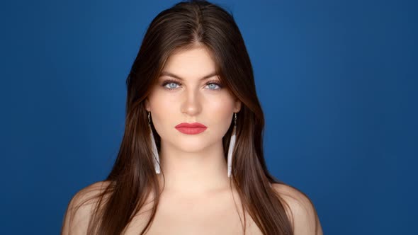 Portrait of a Girl in the Studio on a Blue Background