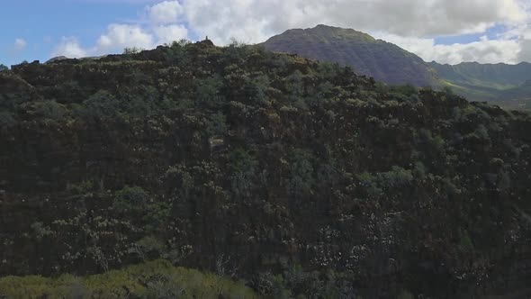 Aerial view of Mountain side revealing beautiful Hawaiian oceanside