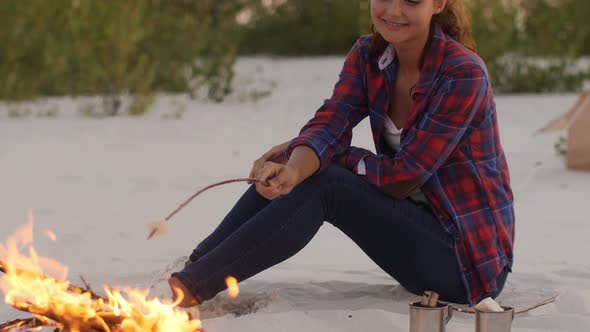 Tourist Woman Camping Near Campfire Outdoors on the Nature