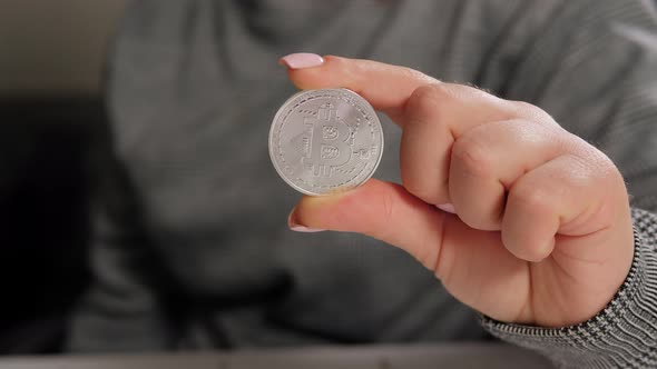 Closeup One Silver Coin with the Bitcoin Symbol in Hand