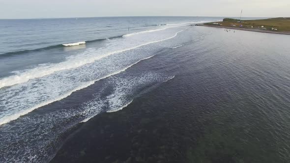 Drone View of Surfers Waiting for a Wave in the Sea at Sunset