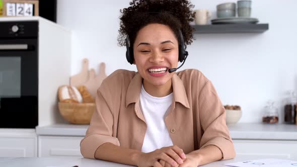 Pretty African American Stylish Girl with Headset Mentor or Student Conducts an Online Meeting with