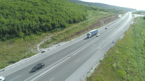 Drone Following Big Blue Cargo Transportation Truck on Highway Traffic