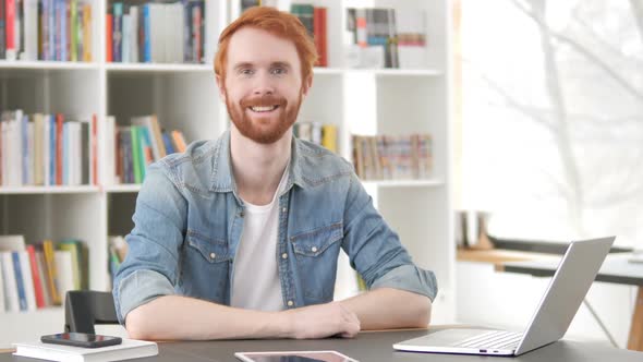Smiling Casual Redhead Man Sitting at Work