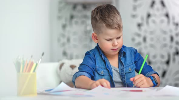 Male Kid Having Creative Imagination Confidently Drawing Cartoon Picture on Paper