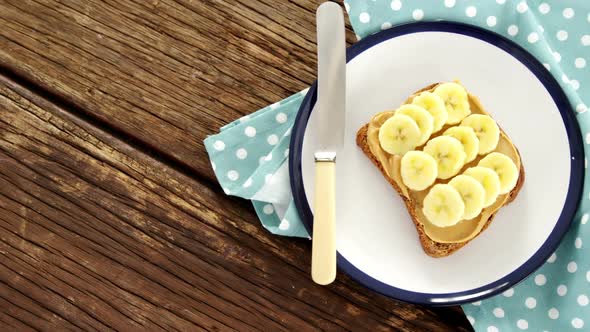 Sliced bananas spread on brown bread in plate