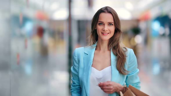 Portrait of Smiling Shopaholic Woman Posing at Modern Shopping Mall