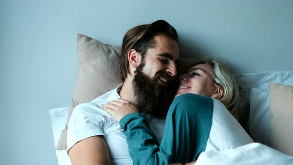 Couple kissing on bed in bedroom 