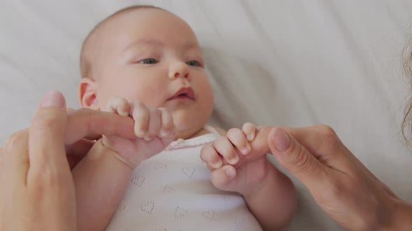 Mother, Holding Newborn Hands . Happy Family Mother and Her Newborn Baby Together. Maternity Concept