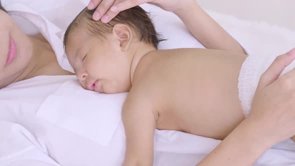 Sleeping newborn baby on mother's body