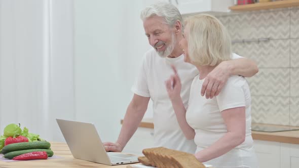 Loving Old Couple Doing Video Call on Laptop in Kitchen