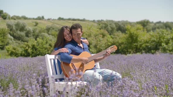 Cute Couple with Guitar Bonding in Lavender Field