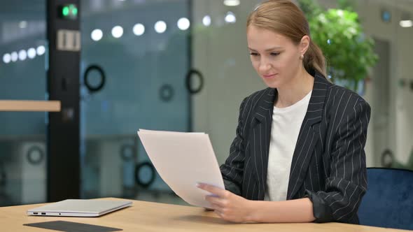 Hardworking Businesswoman Reading Documents in Office 