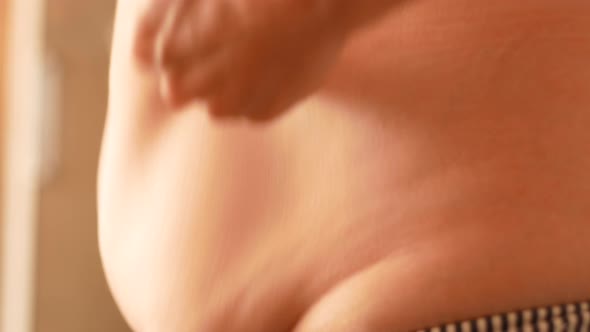 Close-up of a large female belly as a result of obesity and malnutrition.