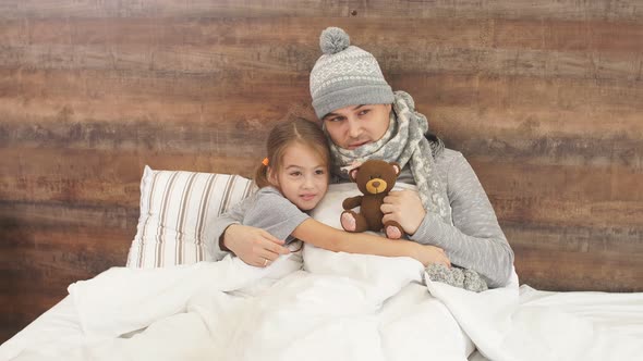 Kid Girl Sit on Bed with Ill Father Having High Temperature