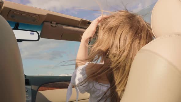 Young beautiful and smiling hipster girl in convertible car