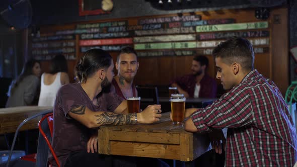 Guys chatting while drinkging a beer in a bar in Argentina