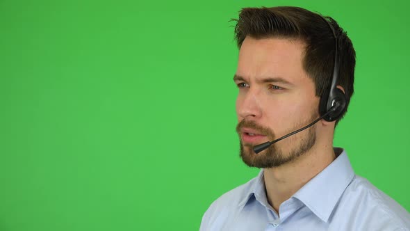 A Young Handsome Call Center Agent Talks Seriously To a Caller - Closeup - Green Screen Studio