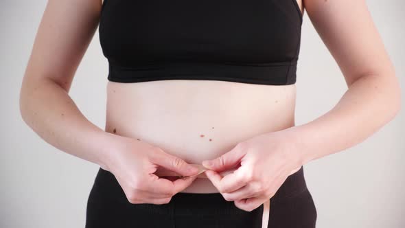 A Woman Measures the Circumference of the Abdomen with a Centimeter Tape Closeup